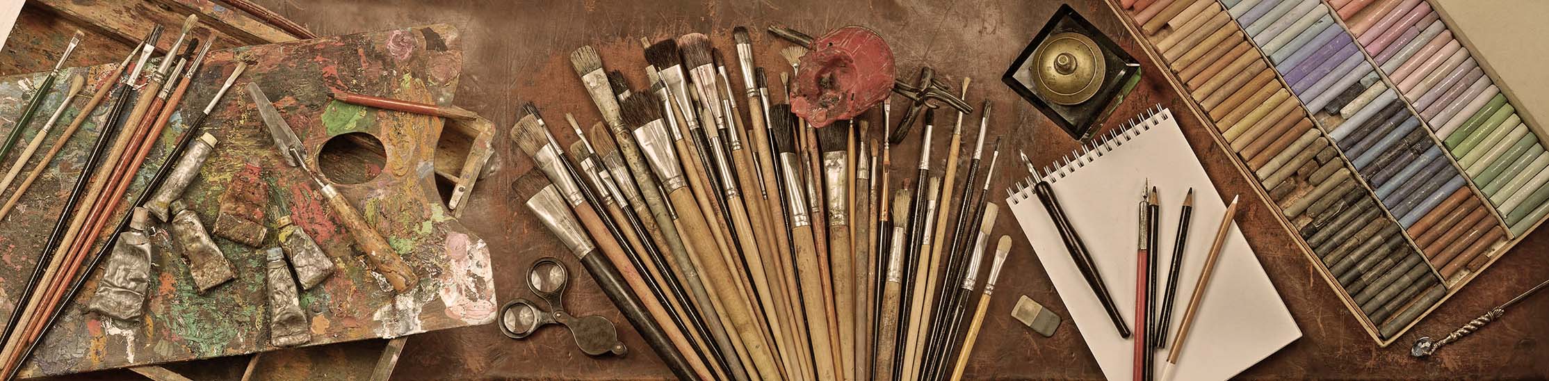 Picture of the tools of a painter. Brushes, pencils, pastel colors and paper.